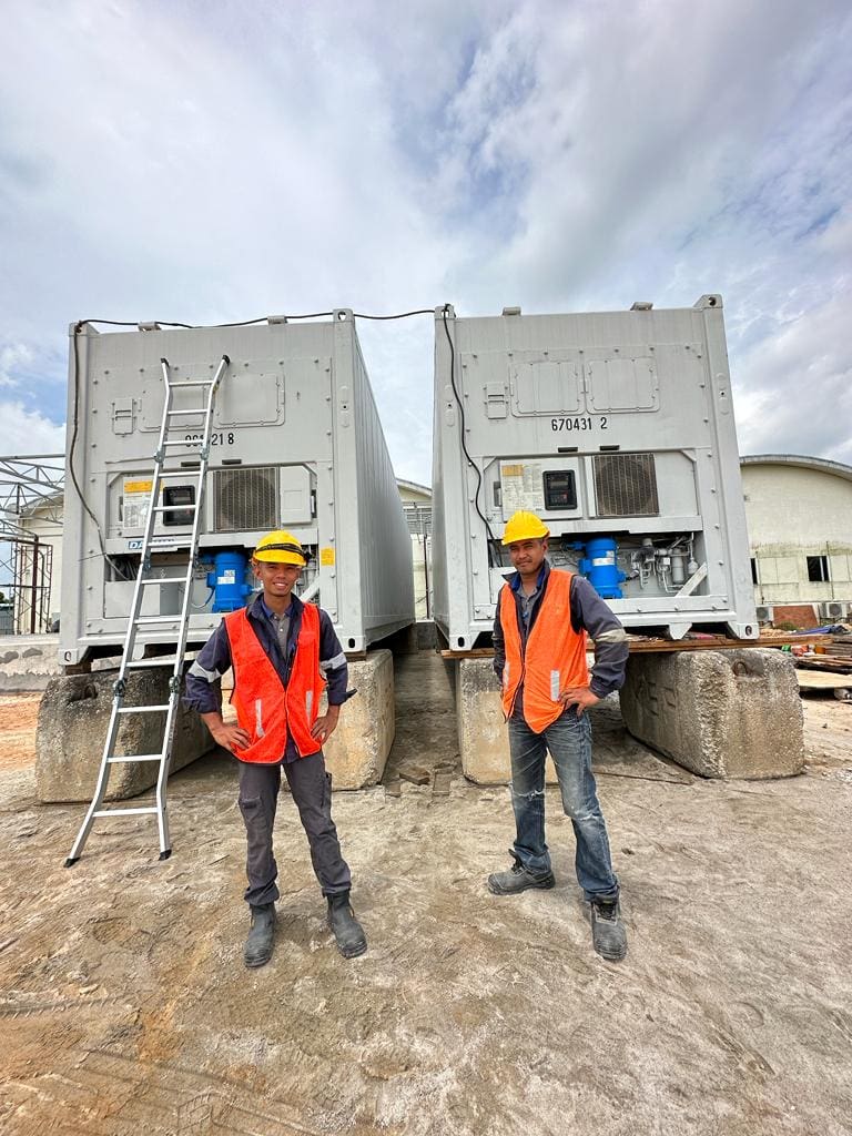 NY Container experienced technicians standing in front of two reefers containers