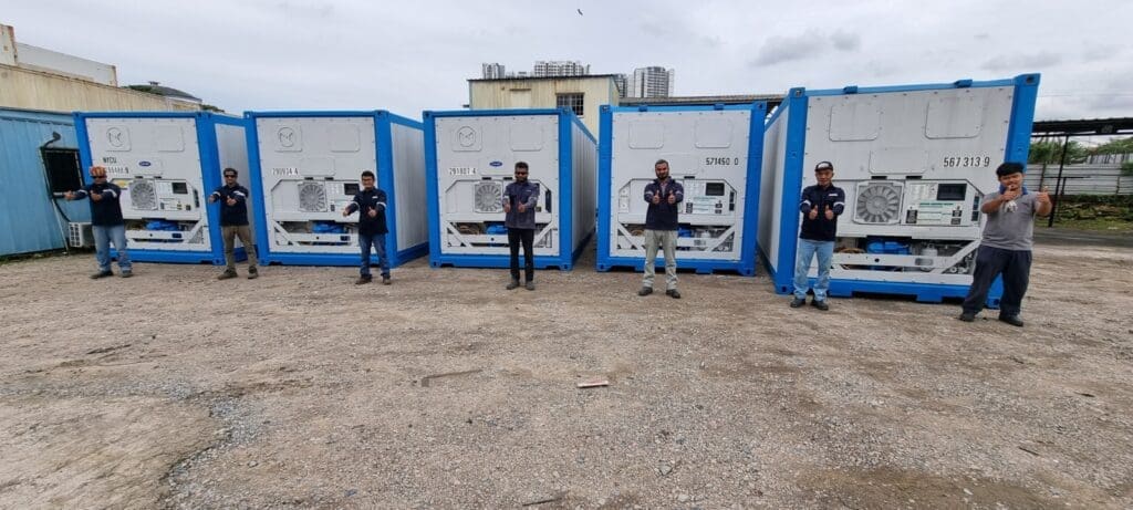 Six NY Container workers standing in front of blue reefer containers modified with technical equipment.